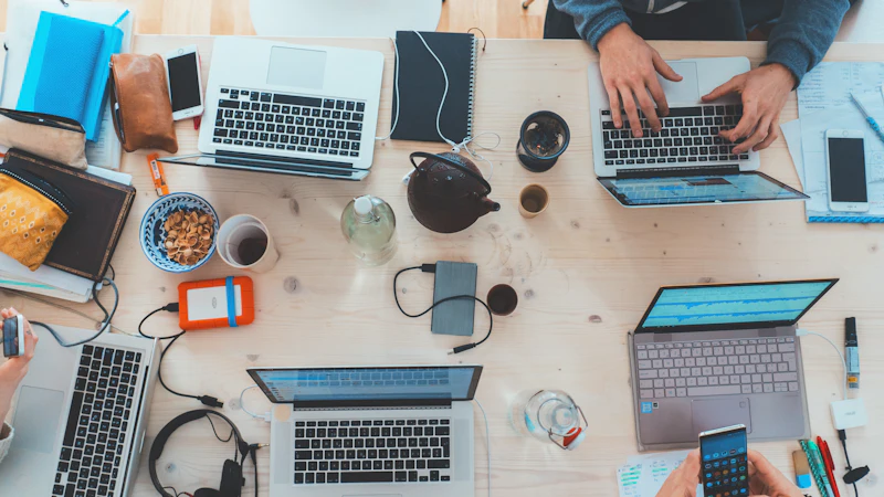 Startup ekibi ortak masada dizüstü bilgisayarlarla çalışıyor